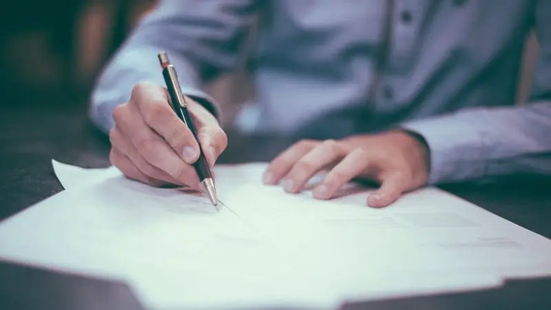 Hand signing a settlement document — car accident lawyer fees and costs in Meriden, CT