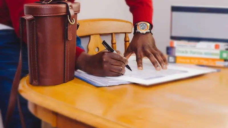 Person filling out a claim form at a table — car accident lawyer fees and costs in New Haven, CT